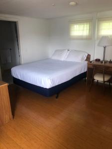 duże łóżko w pokoju z biurkiem i łóżkiem o wymiarach 60 cm w obiekcie Executive Motel w mieście Old Orchard Beach