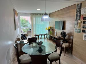 a dining room with a glass table and chairs at Flat 301 Villa Hipica Resort - Gravatá, PE in Gravatá