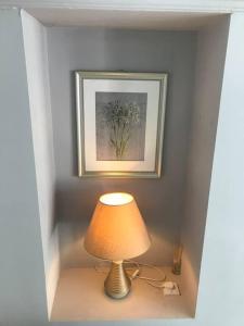 una lámpara en una mesa en una habitación con una foto en Abbotts Mews Apartment York City Centre en York