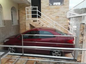 a red car is parked in a parking lot at Flat Aju - Um jeitinho especial de se hospedar em Aracaju. Uma verdadeira suíte master todo mobiliado no capricho só para você. in Aracaju