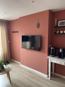 uma sala de estar com televisão na parede em Zwikker aan de Haven em Lelystad