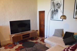 a living room with a couch and a flat screen tv at La Terrazza sull'Alba in Montalcino