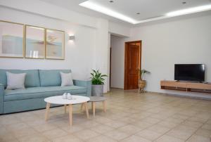 a living room with a blue couch and a table at Rastoni Chania - Guests Apartment in Chania