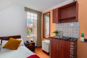 a bedroom with a bed and a sink in it at ApartaSuites & Hotel Bogota Plaza 36 in Bogotá