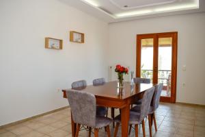 a dining room table with chairs and a vase of flowers at Rastoni Chania - Guests Apartment in Chania