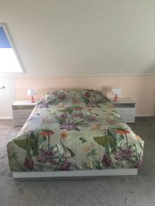 een slaapkamer met een bed met een bloemenbed bij Op de Lutter Esch in Lutten