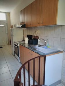 a kitchen with a sink and a stove and refrigerator at Cosy Studio Down Town in Kavala