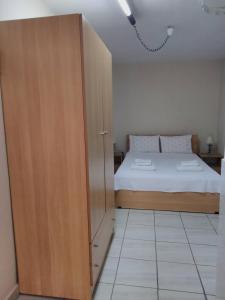 a bedroom with a bed and a wooden cabinet at Cosy Studio Down Town in Kavala