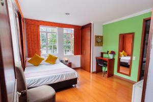 a bedroom with a bed with yellow pillows and a mirror at ApartaSuites & Hotel Bogota Plaza 36 in Bogotá +282 photos
