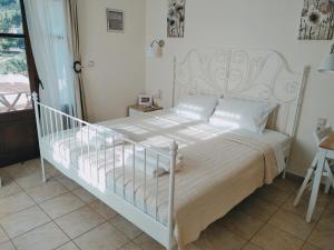 1 dormitorio con 1 cama con marco blanco en Nostra Casa di Hovolo, en Neo Klima