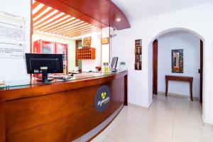 a lobby with a counter with a computer on it at ApartaSuites & Hotel Bogota Plaza 36 in Bogotá