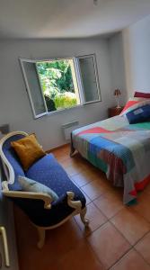 科洛布里埃Jardin d'amis的一间卧室，里面有一张床、一把椅子和一扇窗户