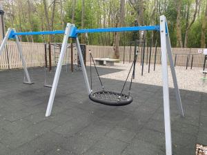 a swing set in a park with a bench at Sun&Sea in Palanga