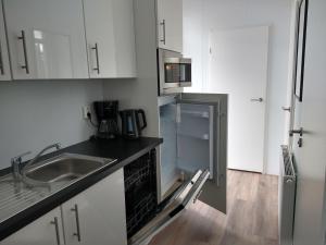 uma cozinha vazia com um frigorífico e um lavatório em Lathumlodge met parkvoorzieningen em Lathum