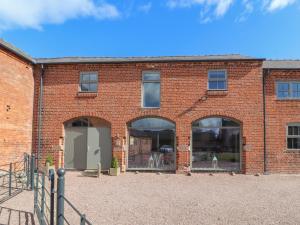 een gebouw van rode baksteen met drie grote ramen bij The Cart House in Whitchurch