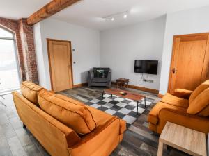 ein Wohnzimmer mit 2 Sofas und einem TV in der Unterkunft The Cart House in Whitchurch