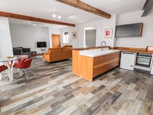 a kitchen with a sink and a table and a living room at The Cart House in Whitchurch