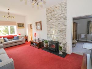 a living room with a fireplace and a red carpet at Stubb Oak in Malvern Wells