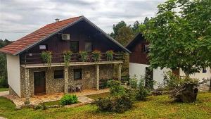a house with plants on the balcony of it at Guest House Iva in Slunj