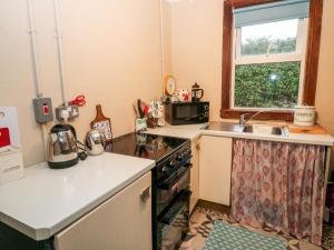 a kitchen with a sink and a stove top oven at Lehane's Cottage in Macroom