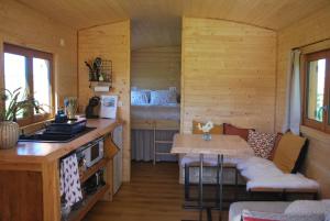 a room with a kitchen and a table in a cabin at La Roulotte des Mohuques in Mont-Saint-Aubert