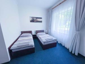 two beds in a small room with a window at Minihotel Vitex in Prague