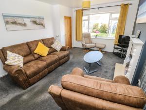 a living room with a couch and two chairs and a table at 53 St Brides View in Haverfordwest