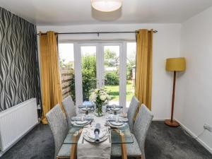 a dining room with a table and chairs and a window at 53 St Brides View in Haverfordwest