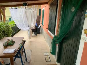 einen Balkon mit einem Tisch und einem grünen Vorhang in der Unterkunft Casa Maia in La Spezia