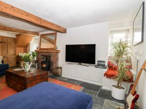 een woonkamer met een tv en een open haard bij Riverside 67 Dorchester Road in Dorchester