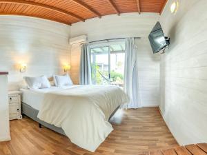 a bedroom with a bed and a tv on a wall at El Diablo y el Mar in Punta Del Diablo