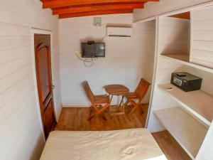 Habitación pequeña con mesa, sillas y TV. en El Diablo y el Mar en Punta del Diablo