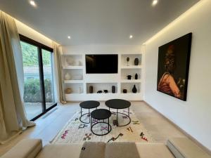 een woonkamer met 2 tafels en een tv bij Mogador in Bonifacio