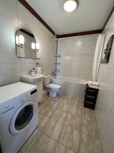 a bathroom with a washing machine and a toilet at Cozy apartment close to Gdansk & Airport in Gdańsk