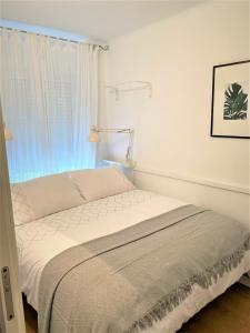 1 cama blanca en un dormitorio con ventana en Bonito Apartamento en Algarrobo-Costa, en Algarrobo Costa