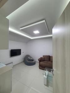 Una sala de estar con un sofá y un televisor. en Apartman Tolosi 2, en Podgorica