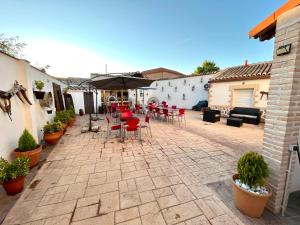 a patio with a table and chairs and an umbrella at Casa El tio Daniel,,,,,,ahora con SPA in Bargas