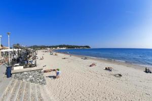 a beach with people laying on the sand and the ocean at Studio le Monroe les pieds dans l'eau 10 m de la mer in La Seyne-sur-Mer