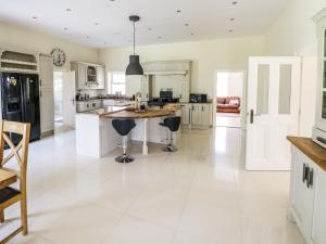 a kitchen with white tile flooring and a large island at Drumlaney in Belturbet