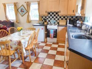 eine Küche mit einem Tisch mit Stühlen und einem Waschbecken in der Unterkunft Borahard Lodge in Newbridge