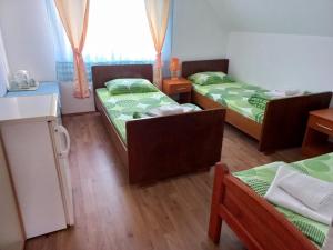 una camera con tre letti e una cucina con finestra di Apartmani Sobe Sljivancanin a Žabljak