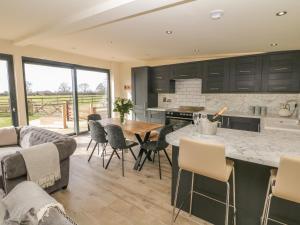 a kitchen and living room with a table and chairs at Saddlers in Stone
