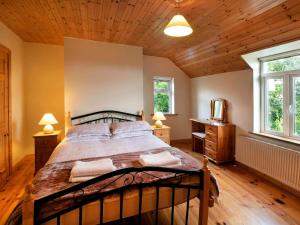 a bedroom with a bed and a wooden ceiling at Glen Gable in Fethard on Sea