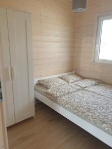 łóżko w pokoju z oknem w obiekcie Szara Gąska w Gąskach w Gąskach