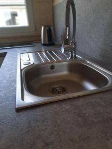 um lavatório de cozinha com uma torneira no balcão em Szara Gąska w Gąskach em Gąski