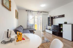 普拉的住宿－Sunny apartment ILI near Amfiteatar，客厅配有白色的桌子和椅子