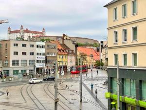 a city with a street with cars and buses at Shone apartment old town in Bratislava