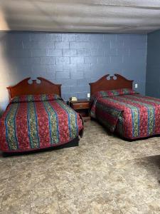 dos camas sentadas una al lado de la otra en una habitación en Budget Inn en Mineola