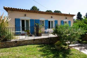 een klein huis met blauwe deuren en een hek bij Les Manaux en Provence in Roquevaire