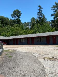 un edificio con puertas rojas y aparcamiento en Budget Inn en Mineola